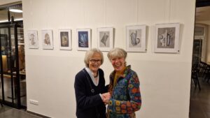 Vernissage Farbe, Form & Fantasie Bernd Wilms Maren Harms und ein Mitglied des Kunstvereins vor Collagen von Bernd Wilms in den Farben grau und blau