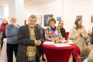 Hans-Peter Junge und andere Teilnehmer am Tisch mit Snacks während der Mitbringausstellung