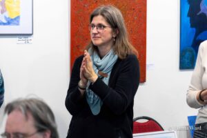 Eine junge Frau vor Gemälden der Mitbringausstellung