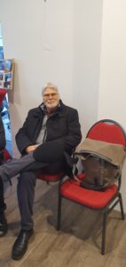 Ein Besucher auf einem roten Stuhl sitzend.