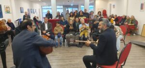 Zwei Musiker spielen die Instrumente Bouzouki und Oud vor vor Publikum