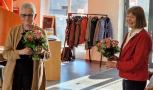 Zwei Frauen, Inke Asmussen und Ilse Demasius mit Blumenstrauß im Foyer des Quartier 36.