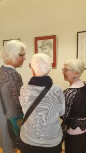 Drei Frauen vor einer Bleistiftzeichnung