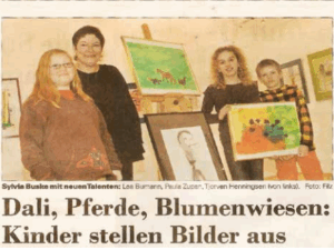 Mallehrerin mit drei Kindern, zwei Mädchen und ein Junge neben einer Staffelei mit selbstgemalten Bildern im Atelier