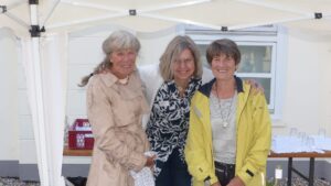 Drei Frauen lächeln in die Kamera.