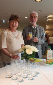 Eine Frau und ein Mann am Getränkebuffet lächeln in die Kamera