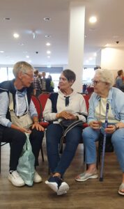 Drei sitzende Frauen im Gespräch.