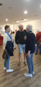 Zwei Frauen und ein Mann im Kreis stehend im Gespräch.