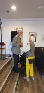 Wulf Schady auf der Treppe stehend und eine Besucherin im Gespräch.