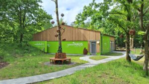 Arten Eden 2025 (3) Foto: M. Roos Gebäude mit der Aufschrift "greenHAUS" mit Holzverkleidung und grüner Verkleidung.