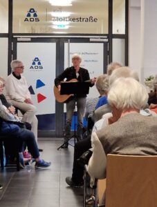 Die Sängerin mit Gitarre im singt im Foyer.