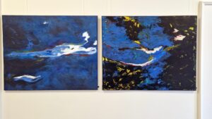 Zwei großformatige Acrylbilder in den Farben blau, schwarz und weiß. Das rechte Gemälde hat noch gelbe Einsprengungen.