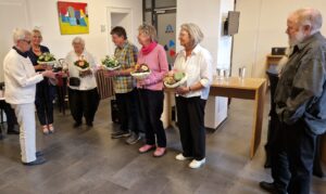 Die fünf KünstlerInnen empfangen die Blumensträuße von Inke Asmussen. Bernd Wilm steht rechts und beoachtet die Szene.