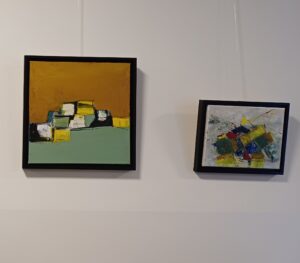 Zwei abstrakte Gemälde in Acryl schwarz gerahmt. Links in den Farben Ocker, lindgrün, weiß und gelb. Die Schattenpartie ist schwarz. Rechst bunte Würfel vor hellgrauen Hintergrund.