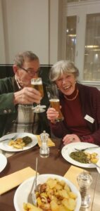 Mitglieder des Kunstvereins sitzen am Tisch und essen Grünkohl.