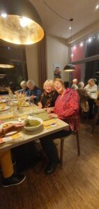 Mitglieder des Kunstvereins sitzen am Tisch und essen Grünkohl.