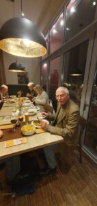 Mitglieder des Kunstvereins sitzen am Tisch und essen Grünkohl.