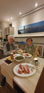 Mitglieder des Kunstvereins sitzen am Tisch und essen Grünkohl.