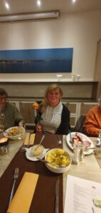 Mitglieder des Kunstvereins sitzen am Tisch und essen Grünkohl.