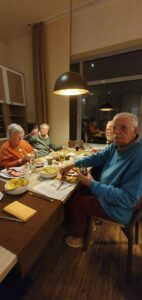 Mitglieder des Kunstvereins sitzen am Tisch und essen Grünkohl.