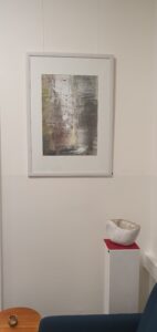 Monotypie mit Skulptur im Vordergrund.