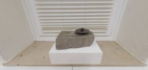 Skulptur aus Sandstein mit Kerzenhalter.