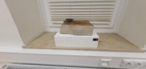 Skulptur aus Sandstein mit Kerzenhalter.