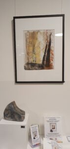 Monotypie in Gelbtönen, davor eine Marmorskulptur.