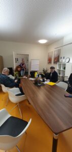 Bernd Wilms, Klaus Müller, Heidmarie Utecht und Jutta Heilmann an einem Nussbaumtisch.