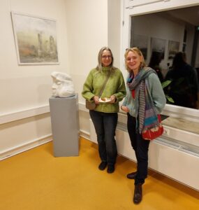 Zwei Frauen vor einer Monotypie und einer Skulptur.