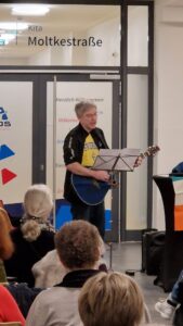 Ein Mann spielt Gitarre im Foyer des Quartier 36.