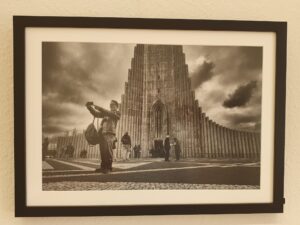 Schwarz-weiß Foto eines Touristen, der ein Selfie vor einer isländischen Kathedrale aufnimmt.
