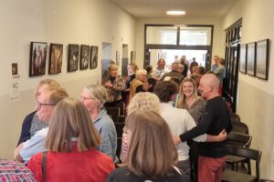 Das Foyer des Quartier 36 voller Gäste der Vernissage. Links und rechts an den Wänden hängen Kunstfotografien.